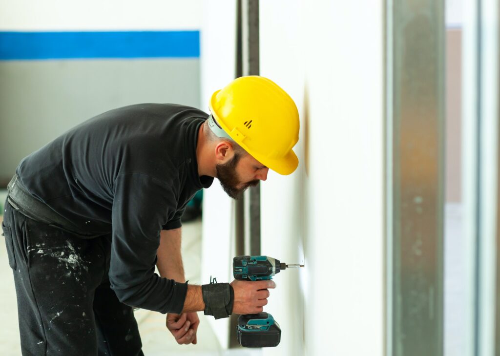 Worker builds a plasterboard wall.